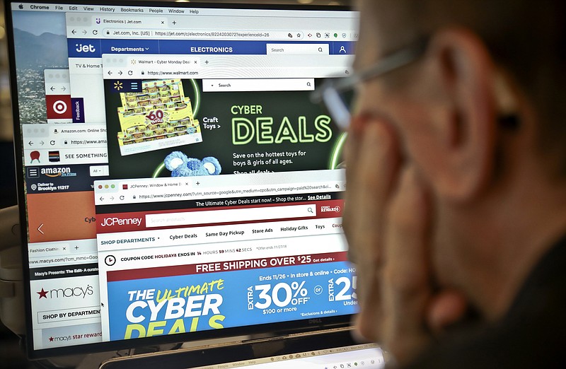 A journalist looks at a computer screen with webpages arranged to show Cyber Monday deals by various online retailers Monday Nov. 26, 2018, in New York. The physical rush of Black Friday and the armchair browsing of Cyber Monday are increasingly blending into one big holiday shopping event as more customers buy items online and pick them up at brick-and-mortar stores. (AP Photo/Bebeto Matthews)