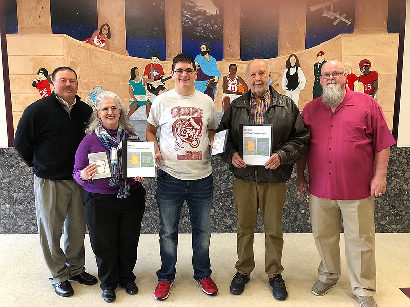 Hope High School senior student Drake Mason, center, presents copies of "Two Hundred Years of Education in Hempstead County" to Southwest Arkansas Regional Archives Archival Manager Melissa Nesbitt, center, left, and SARA Foundation board member Richard Read, center right. Hope Schools Superintendent Dr. Bobby Hart, at left, represented the Hope Public School District, and HHS Principal Bill Hoglund, right, represented the HHS Environmental and Spatial Technology program.