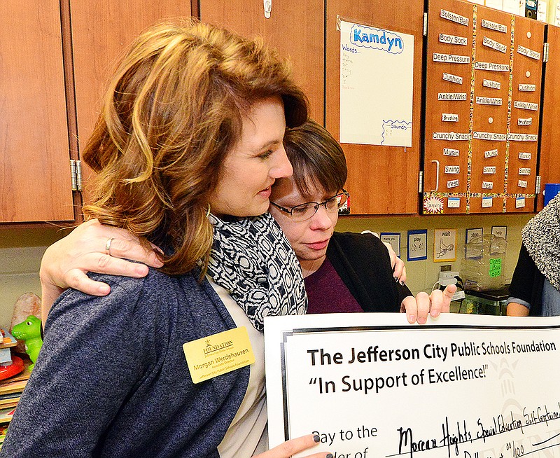 Moreau Heights Elementary School Teacher Cindy Connelly, right, receives a hug Monday from Morgan Werdehausen upon receiving a gift of $10,000 from the Jefferson City Public Schools Foundation. The gift is restricted to the Moreau Heights Special Education Classroom but is unrestricted in how Connelly uses it to benefit her students.