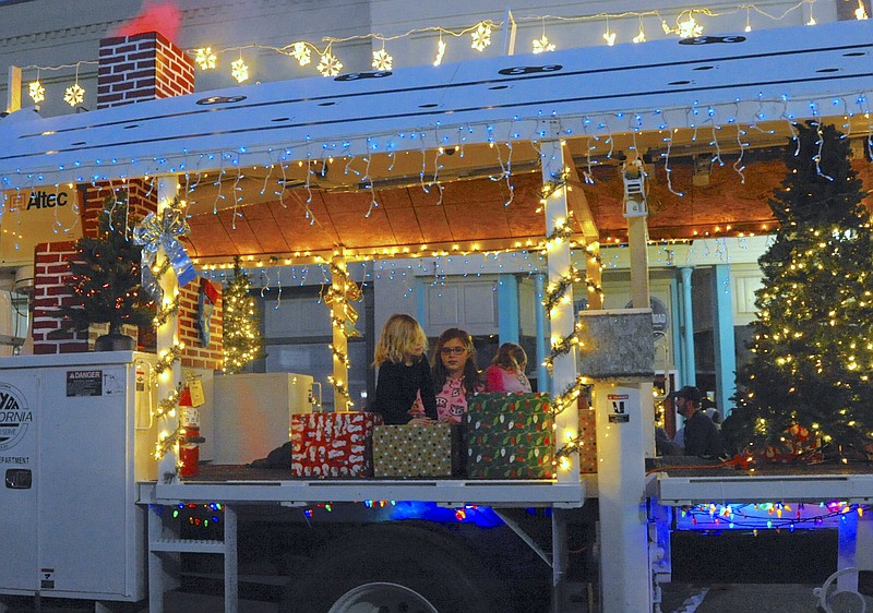 Children sit by the fireplace on a California utilities truck during the 2017 Christmas parade. (Democrat file photo)