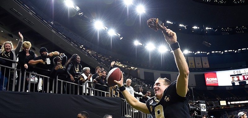 New Orleans Saints quarterback Drew Brees (9) responds to the fans with a turkey drumstick as he runs off the field Thanksgiving night after an NFL football game against the Atlanta Falcons in New Orleans, Thursday, Nov. 22, 2018. The Saints won 31-17. (AP Photo/Bill Feig)
