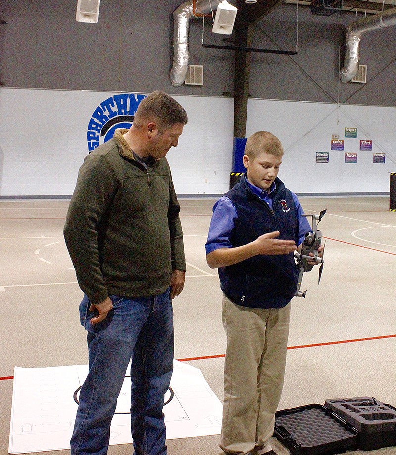 Jody Rosser, a forester with Domtar, listens to Dawson Palmer, a seventh-grader at St. James Day School, talk about the ins and outs of flying drones. Dawson is the general manager of the Drone Leadership Team at St. James.