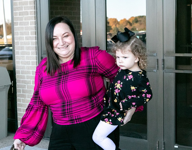 Christina Adams walks out of Bowie County Courthouse Wednesday with her newly adopted 2-year-old daughter, Braylee Sepulvado, in New Boston, Texas. Wednesday was National Adoption Day. Four families in Bowie County adopted children into their families at the courthouse.