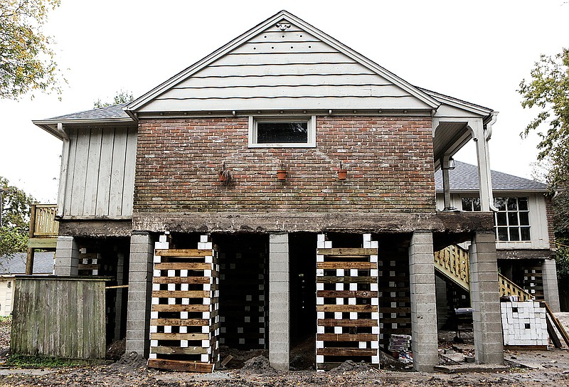 This home shown Dec. 6, 2017, in the Meyerland neighborhood of Houston is in the process of being raised by Arkitekture Development. Medical experts are seeking people in Texas displaced by Hurricane Harvey for a study on possible respiratory problems. 