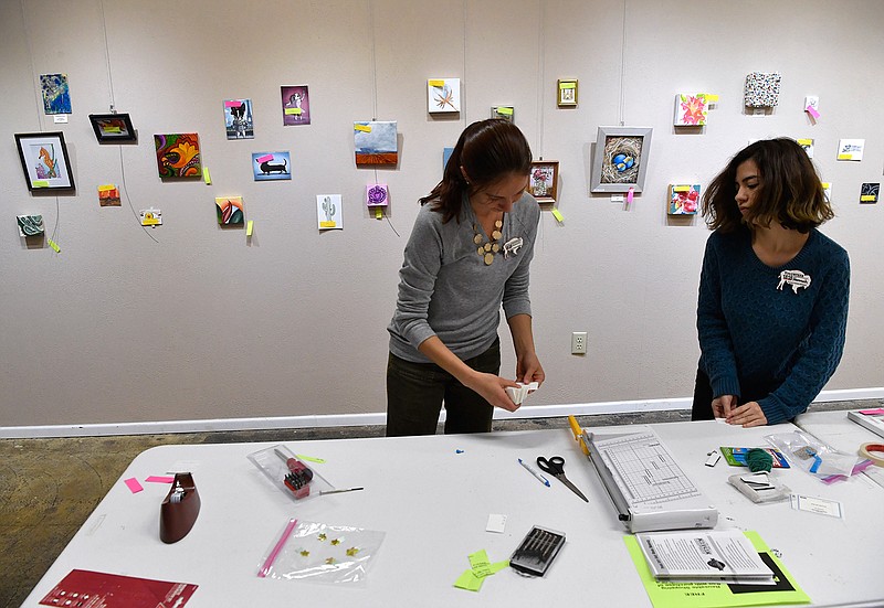 Laura Greenwood, left, the manager at the 1818 Arthouse gallery, prepares the show "Tiny Art!" with the help of Hannah DeLeon on Nov. 7, 2018, at the gallery in Snyder, Texas. The gallery's show of small artwork will be up until Dec. 22.