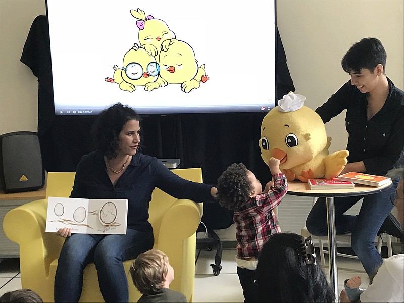 In this Sept. 23, 2018, photo Susie Jaramillo, chief creative officer of Encantos Media Studios, reads her book "Los Pollitos" to children at an event to celebrate Hispanic Heritage Month at the Children's Museum of Manhattan in New York. (AP Photo/Alexandra Olson)