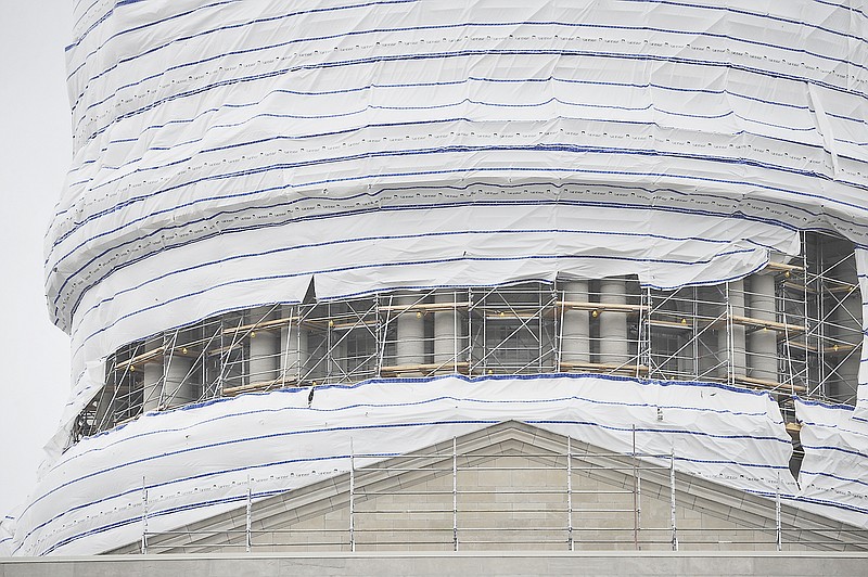 Winds reaching as high as 40 mph over the weekend tore part of the wrap used to enclose the Capitol Dome, exposing the scaffolding, as shown here Monday. Workers will reapply the wrap in order for tradesmen to continue working in the cold weather.