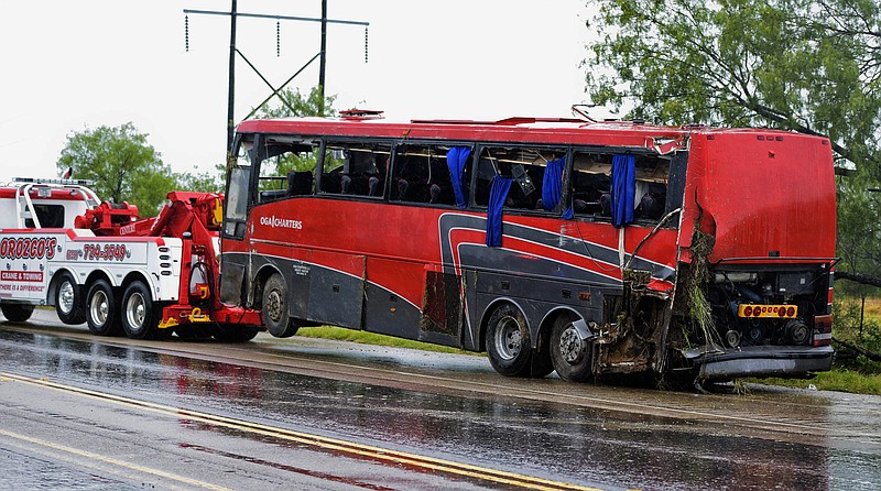 In this May 14, 2016, file photo, a damaged charter bus is hauled away after a fatal rollover in far South Texas. The National Transportation Safety Board released its final report on the crash Tuesday, Dec. 4, 2018, saying the Texas driver suffering from "acute sleep deficit" failed to maintain his lane and caused his passenger bus to careen out of control, causing a wreck. (Danny Zaragoza/The Laredo Morning Times via AP, File)