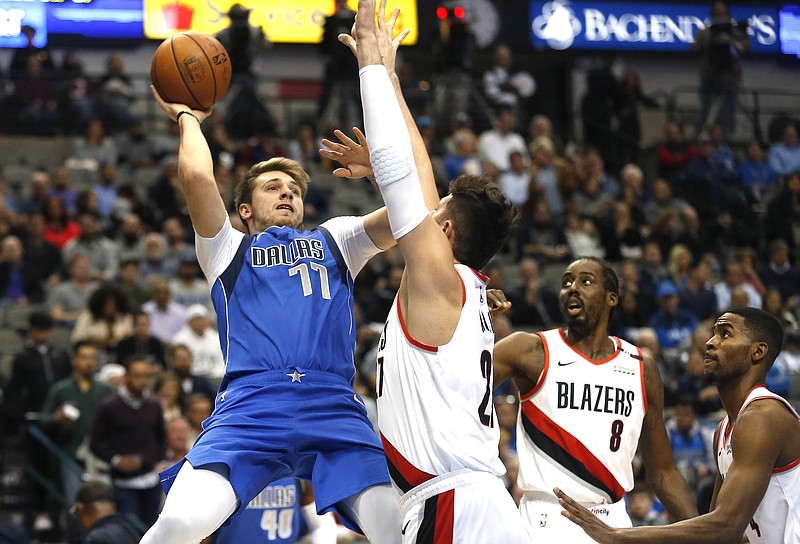 Dallas Mavericks forward Luka Doncic (77) attempts a shot over Portland Trail Blazers center Jusuf Nurkic (27) as Portland Trail Blazers Al-Farouq Aminu (8) and Maurice Harkless (4) look on during the first half of an NBA basketball game, Tuesday, Dec. 4, 2018, in Dallas. (AP Photo/Ron Jenkins)