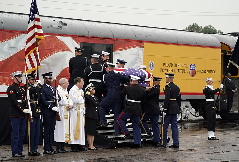 The flag-draped casket of former President George H.W. Bush is carried by a joint services military honor guard Thursday, Dec. 6, 2018, in Spring, Texas, as it is placed on a Union Pacific train. (AP Photo/David J. Phillip, Pool)