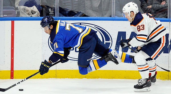 Jordan Nolan of the Blues dives for the puck in front of Matt Benning of the Oilers during the second period of Wednesday night's game in St. Louis.