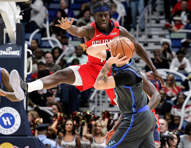 New Orleans Pelicans guard Jrue Holiday (11) guards Dallas Mavericks forward Luka Doncic (77) in the first half of an NBA basketball game in New Orleans, Wednesday, Dec. 5, 2018. (AP Photo/Scott Threlkeld)