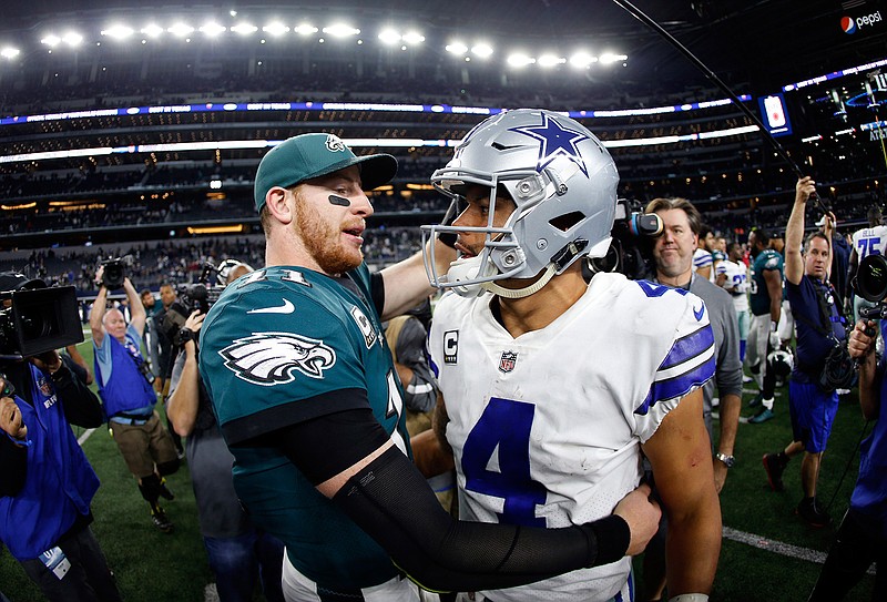 In this Nov. 19, 2017, file photo, Philadelphia Eagles' Carson Wentz, left, and Dallas Cowboys' Dak Prescott, right, greet each other after their NFL football game, in Arlington, Texas. Prescott and the Cowboys saved their season with a win in Philadelphia a month ago. Now Carson Wentz and the defending champion Eagles are trying to do the same in Texas against first-place Dallas on Sunday. (AP Photo/Ron Jenkins, File)