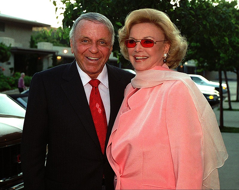 FILE - In this July 11, 1996, file photo, Frank Sinatra, left, and his wife Barbara arrive at Our Lady of Malibu church to renew their wedding vows on their 20th wedding anniversary in Malibu, Calif. The private treasures of the Sinatras were a multimillion-dollar hit at auction. Sotheby’s reported Friday, Dec. 7, 2018, that the couple’s entertainment memorabilia, art, jewelry, books and other personal items sold for $9.2 million, about twice their pre-sale estimates. (AP Photo/Mark J. Terrill, File)