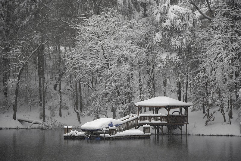 A dock and gazebo is covered with a thick layer of snow on Lake James, Sunday, December 9, 2018 in Morganton, N.C. Over a foot of snow fell in the area creating a winter wonderland. (AP Photo/Kathy Kmonicek)