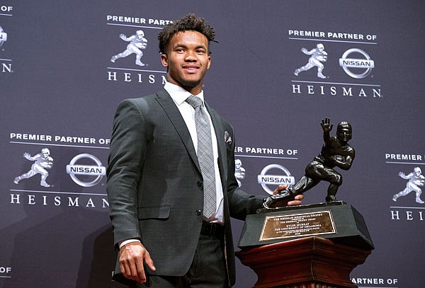 Oklahoma quarterback Kyler Murray poses with the Heisman Trophy after winning the award Saturday night in New York.