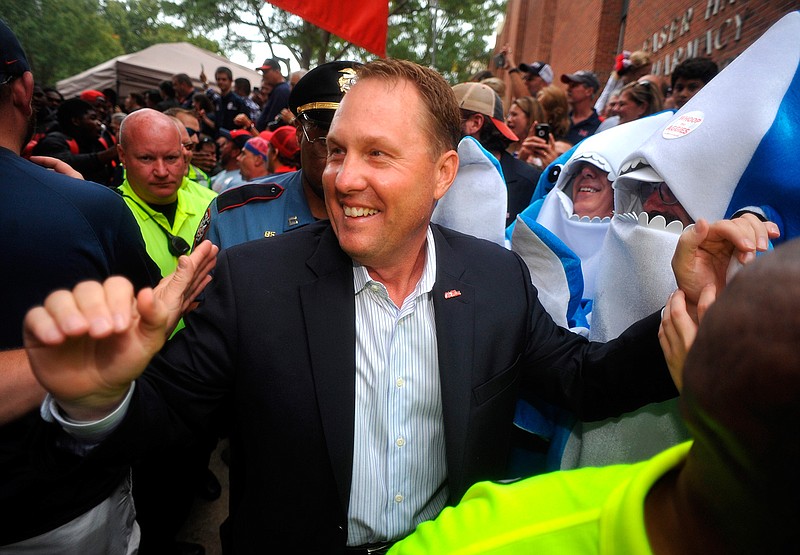 In this Oct. 24, 2015, file photo, Ole Miss Rebels head coach Hugh Freeze walks through fans on the way to the stadium in Oxford, Miss. Liberty has hired former Mississippi coach Hugh Freeze to lead its football program. A person familiar with the situation told The Associated Press that the Flames have tabbed Freeze as their next coach. The person spoke to the AP on the condition of anonymity because neither the school nor Freeze has publicly announced the decision. Liberty has scheduled a news conference to "name Liberty's next head football coach" for Friday afternoon, Dec. 7, 2018. (Bruce Newman/The Oxford Eagle via AP, File)