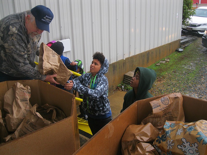 Members of the Boy Scouts of America and local residents hand food supplies to Steve Knollenberg during the annual Caddo Area Council's Scouting for Food and Books Drive Saturday. Knollenberg is the council's district director.
