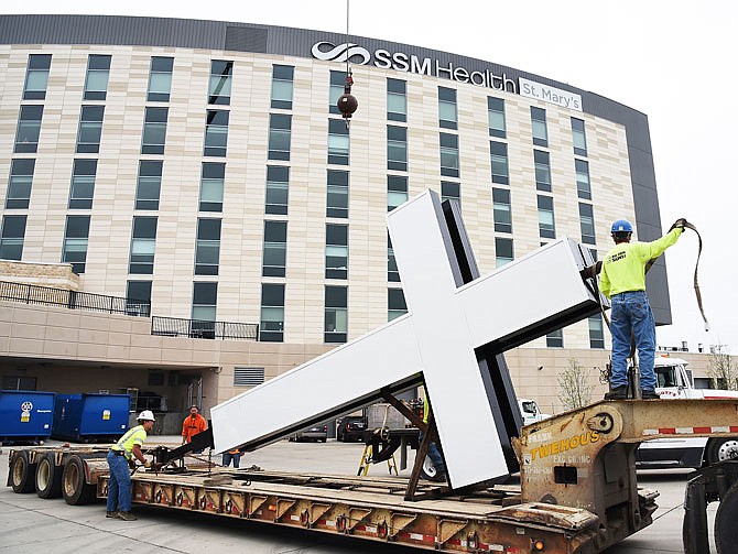 In April 2016, crews hoisted and set this lighted cross atop St. Mary's Hospital at 2505 Mission Drive. The 12-by-22 cross is lit by LED lights inside the aluminum framework. If MU Health purchases St. Mary's Hospital, Catholic icons and relics from the hospital would be taken by SSM Health, officials said.