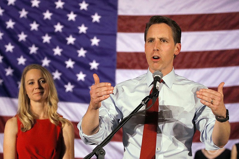 FILE - In this Nov. 6, 2018 file photo, Sen.-elect Josh Hawley makes his victory speech while his wife Erin watches in Springfield, Mo. (AP Photo/Charlie Riedel File)