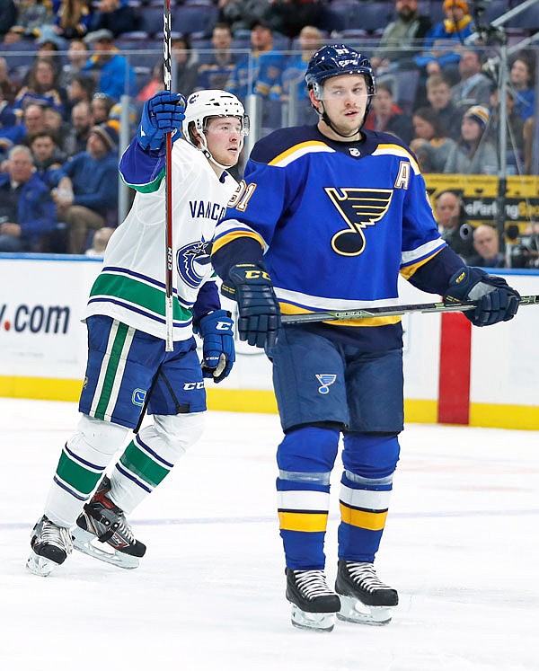 Brock Boeser of the Canucks celebrates after scoring as Vladimir Tarasenko of the Blues skates past during the third period of Sunday's game in St. Louis.