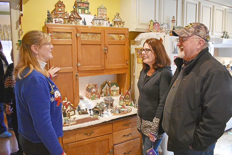At left, Tina Sellner shows her snow village to Cecile Landrum and Steve Waters during Sunday's annual Christmas Tour of Homes hosted by Heisinger Bluffs and St. Joseph's Bluffs.