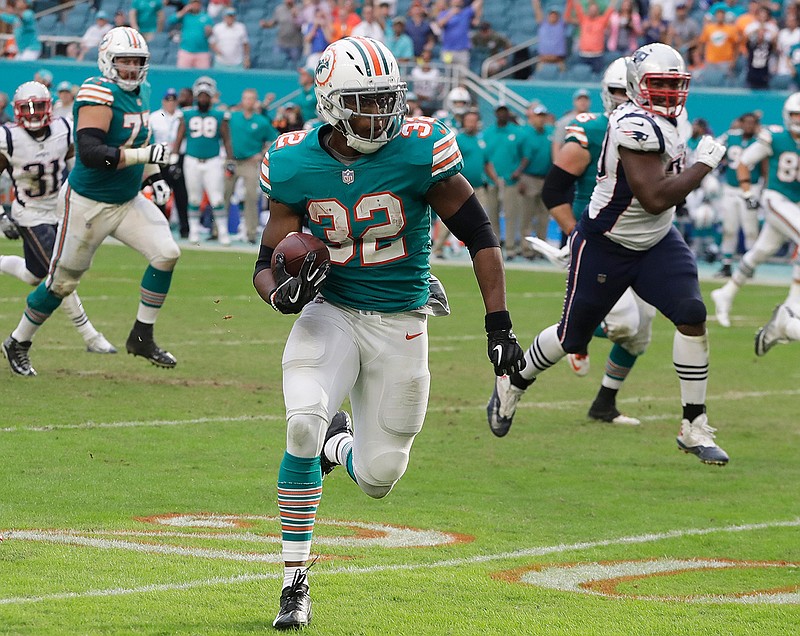 Miami Dolphins running back Kenyan Drake (32) runs for a touchdown during the second half against the New England Patriots on Sunday in Miami Gardens, Fla. The Dolphins defeated the Patriots, 34-33.