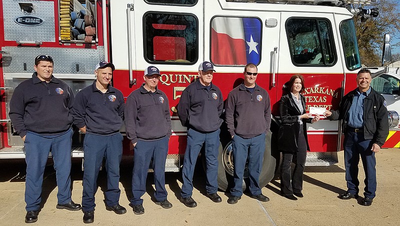 Members of Texarkana, Texas, Fire Fighters Association Local 367 present a check for more than $20,600 to the Muscular Dystrophy Association on Tuesday at Fire Station Five in Texarkana, Texas. The union raised the money over three weekends this fall during its annual Fill the Boot campaign. The money will help fund clinics, drug research and summer camps for children with muscular dystrophy and related diseases. Pictured, from left, are Jeremy Gingery, Mitchel Wood, Lane Peeples, Ken Chamblee, Josh Hawkins, Shreveport MDA Business Development Director Jennifer Kingery and chapter treasurer and Fill the Boot coordinator Craig Hicks.
