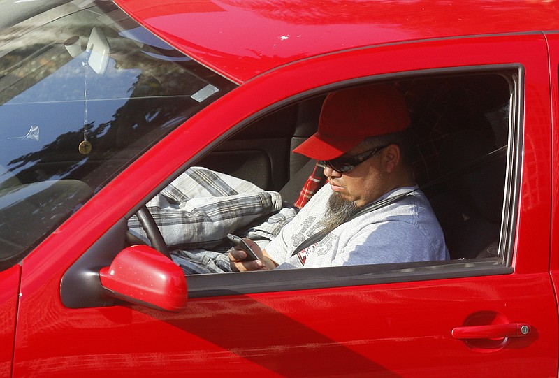 FILE  - In this Dec. 14, 2011 file photo, a driver uses a cellphone while driving in Los Angeles. (AP Photo/Damian Dovarganes, File)