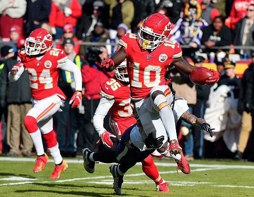 Chiefs wide receiver Tyreek Hill runs past a tackle attempt by Chris Moore of the Ravens during last Sunday's game at Arrowhead Stadium.