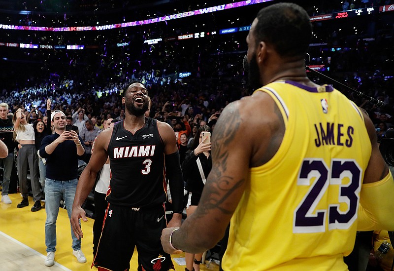 Miami Heat guard Dwyane Wade, left, smiles at Los Angeles Lakers' LeBron James (23) at the end of an NBA basketball game Monday, Dec. 10, 2018, in Los Angeles. (AP Photo/Marcio Jose Sanchez)