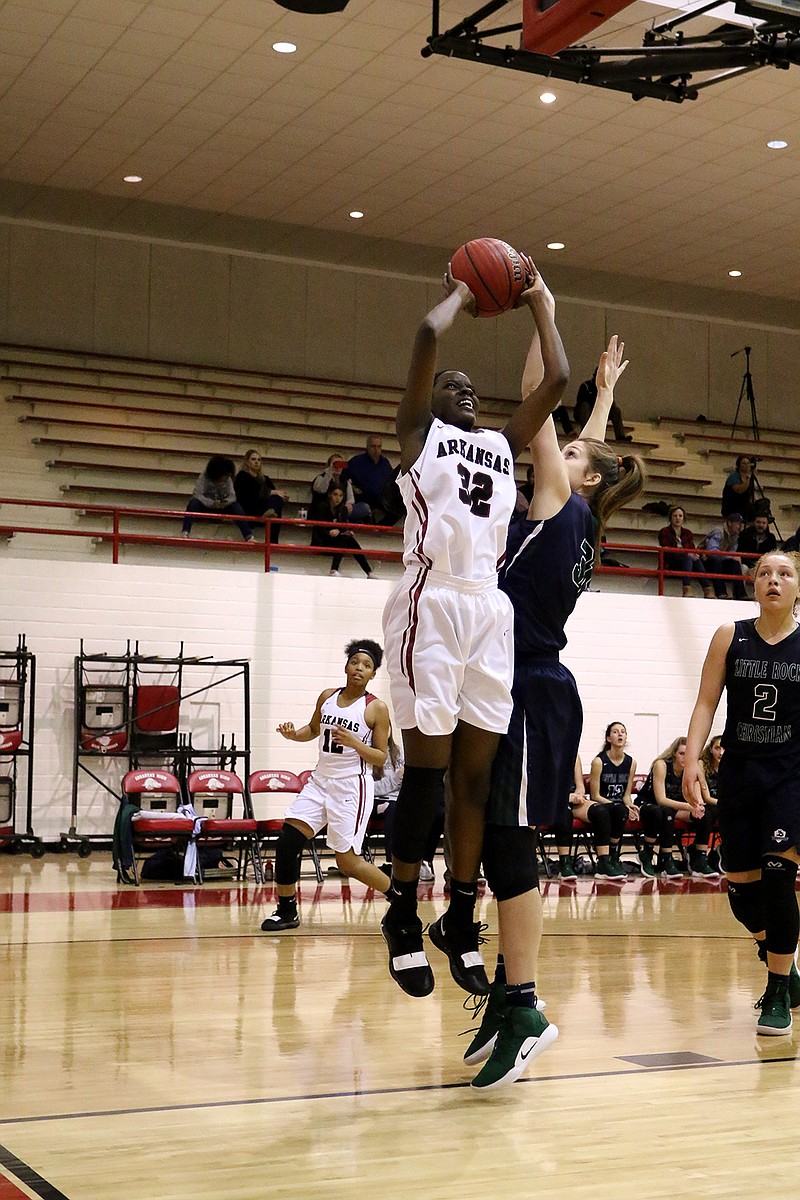 Lady Backs center Cedriana Daniels jumps up to take a shot while being guarded by Little Rock Christian Academy's Kaylee Hopper on Tuesday at Arkansas High School.