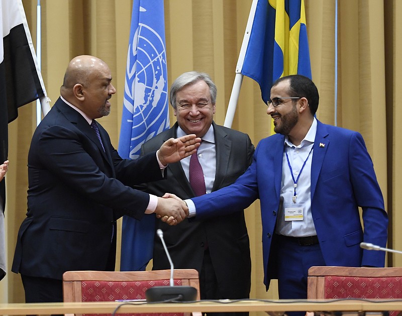 Head of delegation for rebel forces known as Houthis, Mohammed Amdusalem, right, and Yemen Foreign Minister Khaled al-Yaman, left, shake hands together with UN Secretary Geleral Antonio Guterres, during the Yemen peace talks closing press conference at the Johannesberg castle in Rimbo north of Stockholm, Sweden, Thurday Dec. 13, 2018. The United Nations secretary general on Thursday announced that Yemen's warring sides have agreed after week-long peace talks in Sweden to a province-wide cease-fire in Hodeida. (Pontus Lundahl/TT News agency via AP)