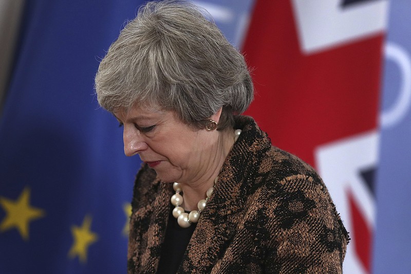 British Prime Minister Theresa May walks by the Union flag and the EU flag as she departs a media conference at an EU summit in Brussels, Friday, Dec. 14, 2018. European Union leaders expressed deep doubts Friday that British Prime Minister Theresa May can live up to her side of their Brexit agreement and they vowed to step up preparations for a potentially-catastrophic no-deal scenario. (AP Photo/Francisco Seco)