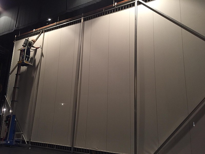 Operations director Randal Conry cleans 25 years of dust from the Perot Theatre's movie screen. (Photo courtesy TRAHC)