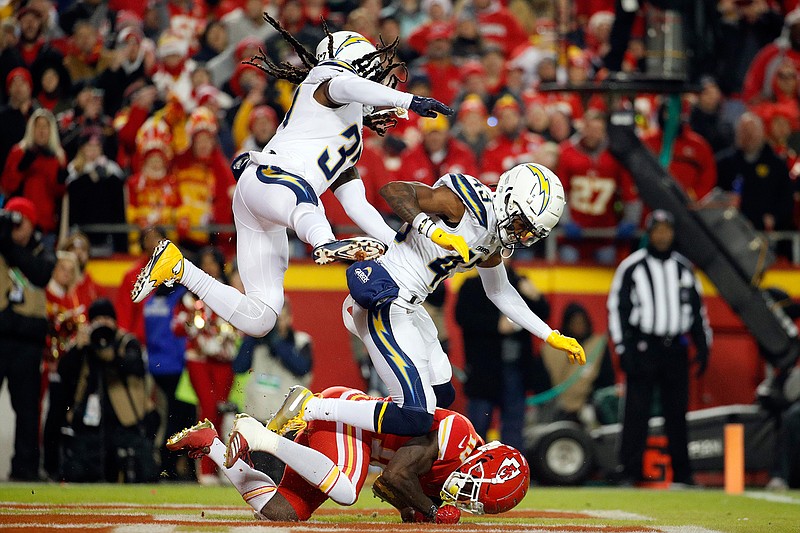 Los Angeles Chargers safety Jahleel Addae (37) and cornerback Michael Davis (43) leap over Kansas City Chiefs wide receiver Tyreek Hill (10) on an incomplete pass during the first half of an NFL football game in Kansas City, Mo., Thursday, Dec. 13, 2018. (AP Photo/Charlie Riedel)