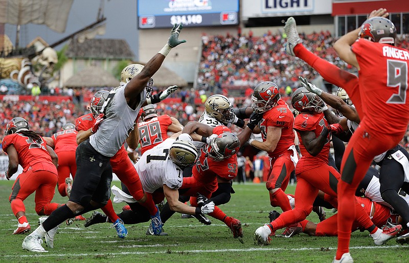 In this Sunday, Dec. 9, 2018 file photo, New Orleans Saints Taysom Hill (7) blocks a punt by Tampa Bay Buccaneers' Bryan Anger during the second half of an NFL football game in Tampa, Fla. Saints third-string quarterback Taysom Hill is piling up highlights that have nothing to do with throwing the ball the latest being his momentum-changing blocked punt. The ultimate utility player has made an already good New Orleans team that much more of a contender. (AP Photo/Mark LoMoglio, File)