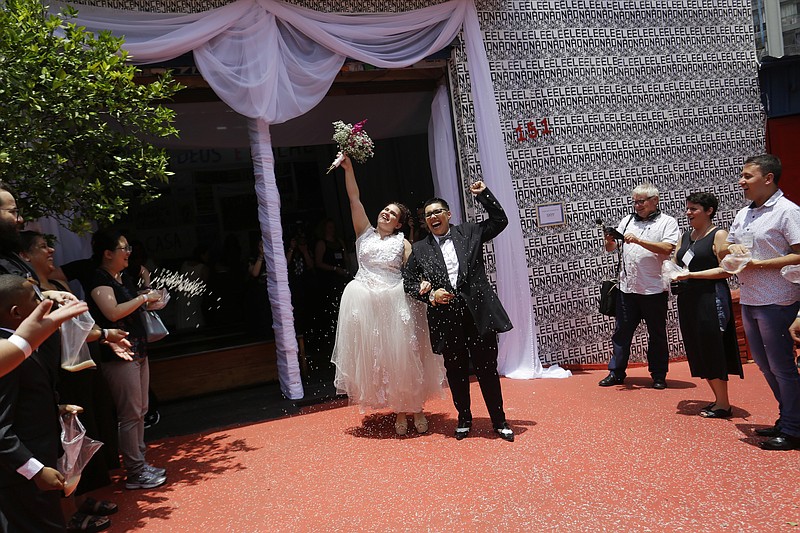 Two women celebrate after getting married in a group marriage of forty same sex couples in Sao Paulo, Brazil, Saturday, Dec. 15, 2018. With the election of ultra-rightist Jair Bolsonaro as president, hundreds of same sex couples began to marry, fearing that the administration of Bolsonaro, who accumulates a history of homophobic and derogatory comments towards gays, could hinder the union of people of the same sex.  (AP Photo/Nelson Antoine)