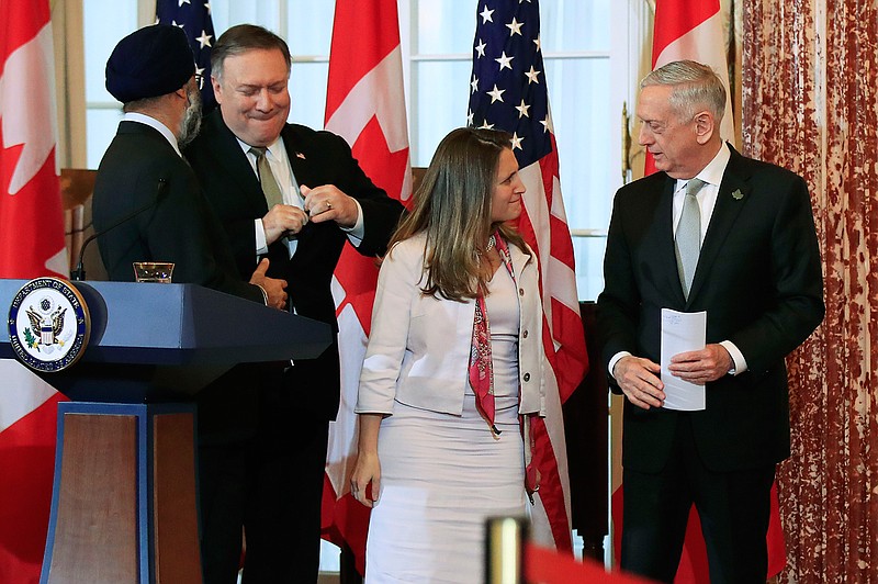 Secretary of State Mike Pompeo, second from left, and Defense Secretary Jim Mattis right, shake hands with their Canadian counterparts Canadian Minister of Foreign Affairs Chrystia Freeland, second from right, and Canadian Minister of Defense Harjit Sajjan, left, as they conclude their news conference following a U.S.-Canada 2+2 Ministerial at the State Department in Washington, Friday, Dec. 14, 2018. (AP Photo/Manuel Balce Ceneta)