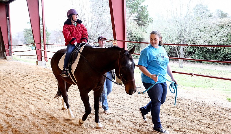 Mercy Bunch rides a horse that is being led by a horse leader at the Runnin' WJ Ranch on Wednesday in Texarkana, Texas.