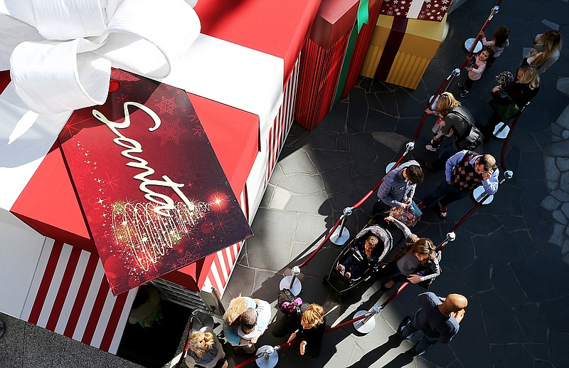 Parents and their children line up for photos with Santa Claus at Santa Monica Place in Santa Monica, Calif., on Friday, Nov. 27, 2015. (Luis Sinco/Los Angeles Times/TNS)