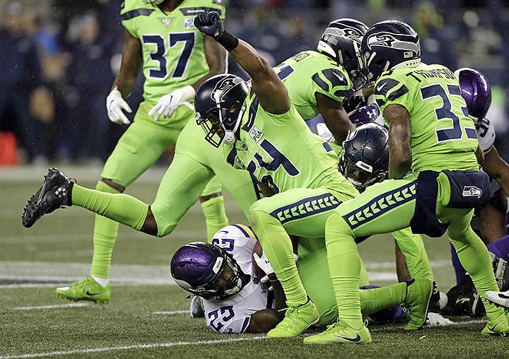 FILE - In this Monday, Dec. 10, 2018, file photo, Seattle Seahawks' Bobby Wagner (54) raises his fist after stopping Minnesota Vikings' Latavius Murray on a fourth down run in the second half of an NFL football game in Seattle. Wagner, making a hefty statement for NFL Defensive Player of the Year, seeks his eighth straight game with at least eight tackles. (AP Photo/Stephen Brashear, File)