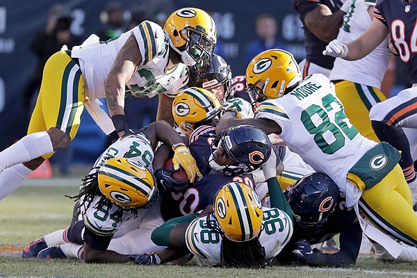 Bears running back Benny Cunningham is tackled by a host of Packers defenders during the second half of Sunday's game in Chicago.