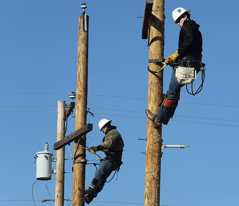 Lee Krumnow, 21, left, and Jordan Tatro, 19, practice climbing poles Nov. 19 in the Electrical Lineworker Technology program at Texas State Technical College in Waco, Texas. 