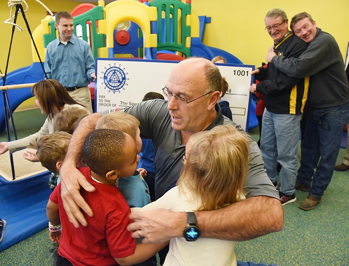 Everyone wanted in on the moment Dec. 17, 2018, so in addition to Tom Henke, in foreground, and other Jefferson City Cosmopolitan Club members receiving numerous hugs from students at The Special Learning Center, Eric Burkett, background right, leans in to hug fellow Cosmo Jim Price. Henke and fellow Cosmos were at the center to deliver the proceeds from previous fundraising efforts.