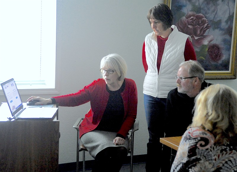<p>Democrat photo/Michelle Brooks</p><p>Moniteau County Library Director Connie Walker shows board members examples of websites and logos to begin the courses toward a new library website, web host and logo.</p>