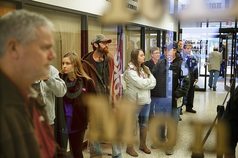 In this Dec. 30, 2015 photo, taxpayers wait in line at the Cole County Collector's office to pay year-end property and real estate taxes.