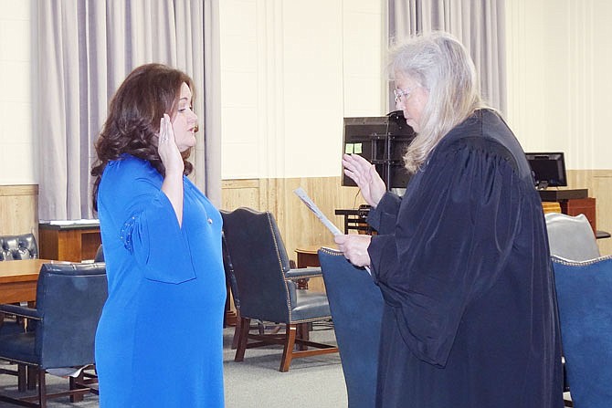 Rhonda Miller, left, newly elected Callaway County clerk, repeats her oath of office after Judge Carol England. Miller and two other officials were sworn in Wednesday.