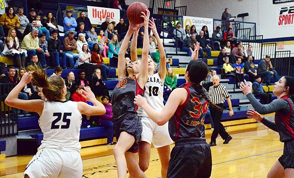 Kylie Bernskoetter of Helias (10) and Bailey Russell of St. Joseph Benton reach for the basketball during Friday night's semifinal in the State Farm Holiday Hoops Invitational at Rackers Fieldhouse.