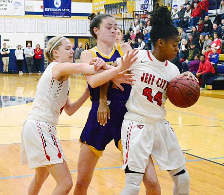 Jefferson City teammates Caitlin Anderson (right) and Hannah Nilges battle Emma Chapman of Hickman for control of the ball during Friday night's semifinal game in the State Farm Holiday Hoops Invitational at Rackers Fieldhouse.